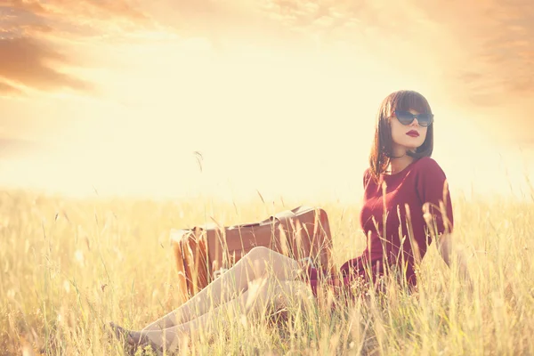 Vrouw met koffer op weide — Stockfoto