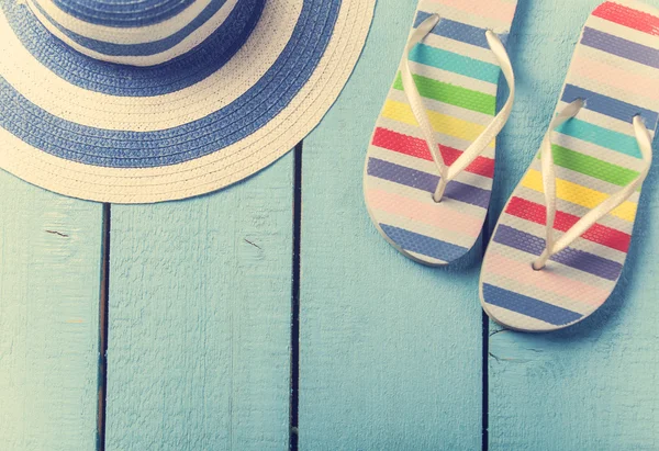 Plaj terlikleri ve mavi ahşap üzerine şapka — Stok fotoğraf