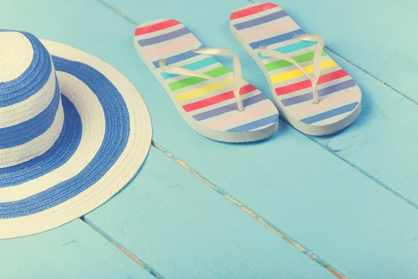 Zapatillas de playa y sombrero en madera azul — Foto de Stock