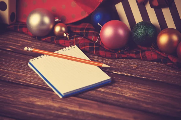 Notebook and pencil with christmas gifts — Stock Photo, Image