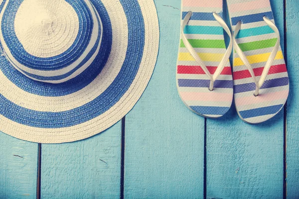 Strand pantoffels en hoed op blauwe hout — Stockfoto