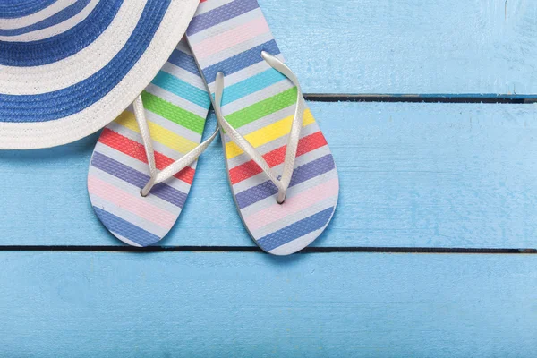 Zapatillas de playa y sombrero en madera azul — Foto de Stock