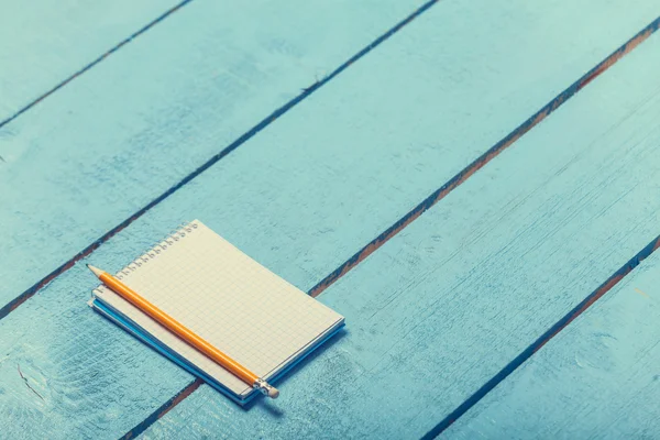 Notebook con matita su tavola in legno blu — 스톡 사진