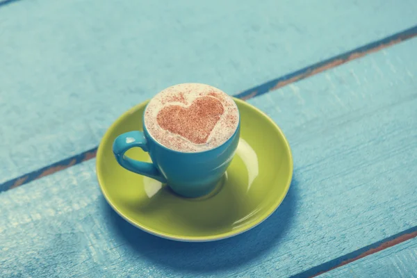 Taza de café con forma de corazón en mesa de madera . — Foto de Stock