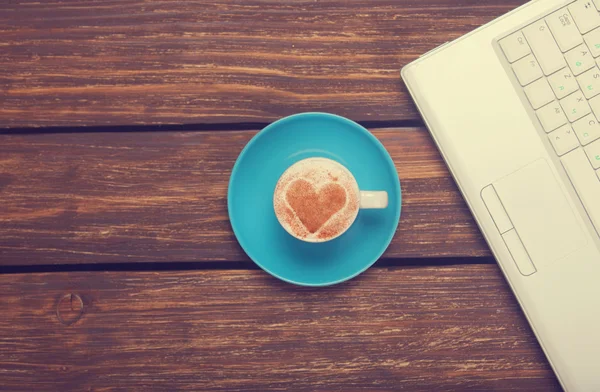 Kopp kaffe med hjärta form och anteckningsbok på träbord. — Stockfoto