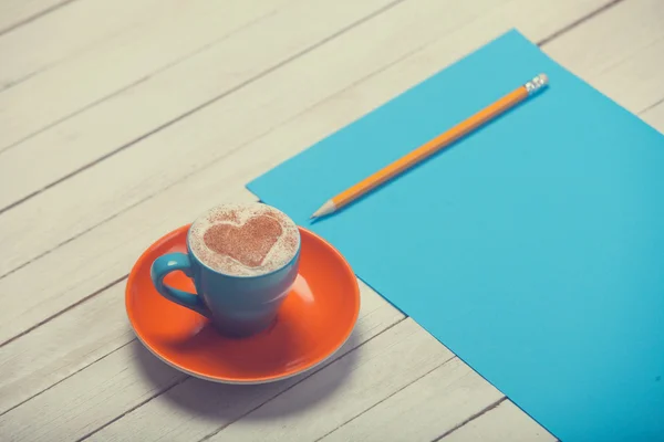 Cup of coffee and paper with pencil — Stock Photo, Image