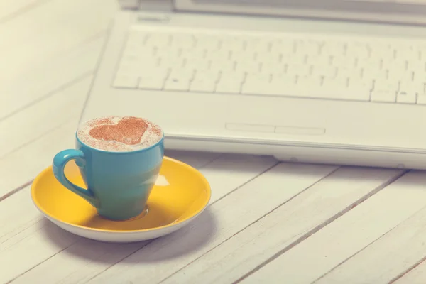 Kopp kaffe med hjärta form och notbook på träbord. — Stockfoto