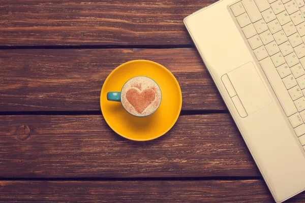 Kopp kaffe med hjärta form och anteckningsbok på träbord. — Stockfoto