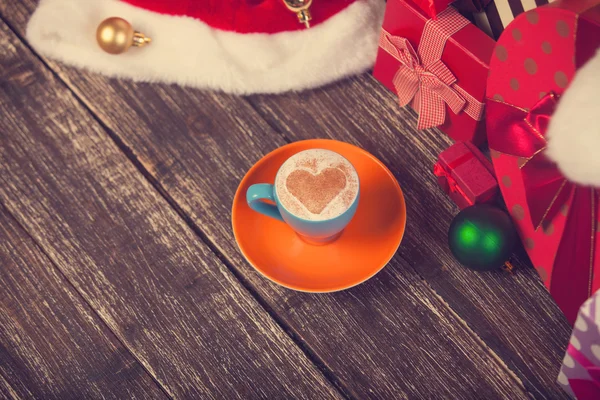 Cup of coffee with heart shape with christmas gifts. — Stock Photo, Image