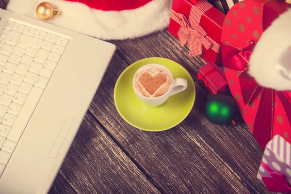 Tasse de café avec forme de coeur, ordinateur portable et cadeaux de Noël . — Photo