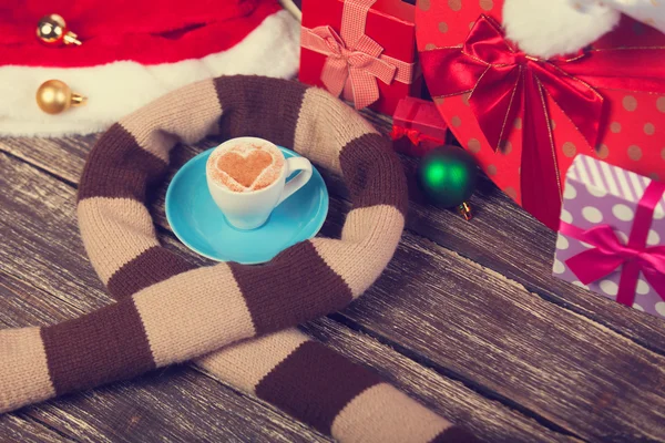 Filiżanka kawy z serca kształt, szalik i Boże Narodzenie prezenty. — Zdjęcie stockowe