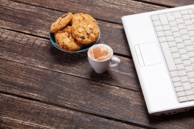 kurabiye ve kahve ile ahşap masa üstünde laptop.