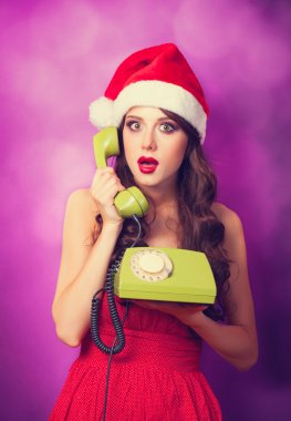 Yeşil telefon ile Noel şapkalı güzel esmer kız