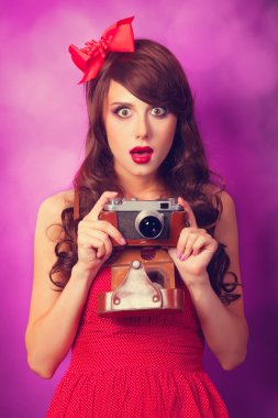 güzel esmer kız mor zemin üzerine retro kamera ile.