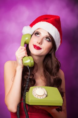 Yeşil telefon ile Noel şapkalı güzel esmer kız