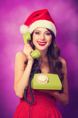 Yeşil telefon ile Noel şapkalı güzel esmer kız