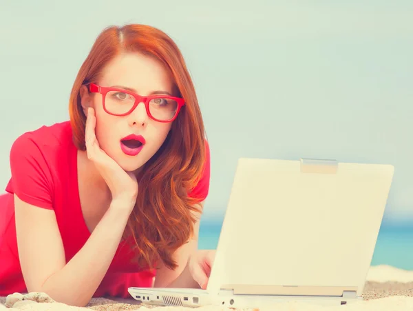 Redhead girl in the glasses with notebook on the beach — Stock Photo, Image