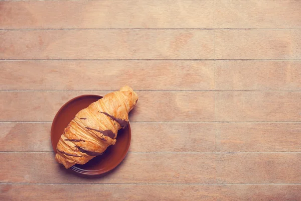 Französisches Croissant auf einem Holztisch — Stockfoto
