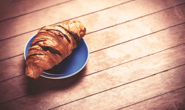 Croissant francés sobre una mesa de madera — Foto de Stock