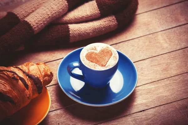 French croissant and cup of coffee on a wooden table — Stock Photo, Image