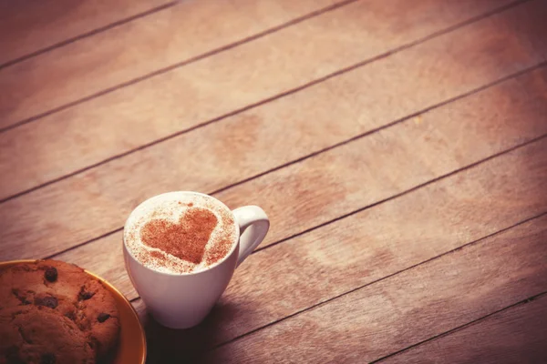 Biscoito e xícara de café na mesa de madeira . — Fotografia de Stock