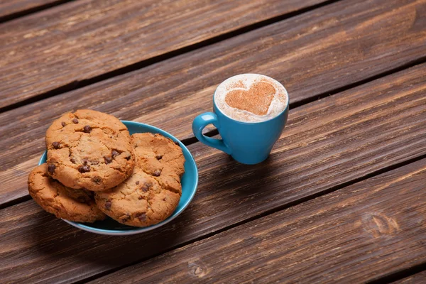 Galleta y taza de café sobre mesa de madera . —  Fotos de Stock