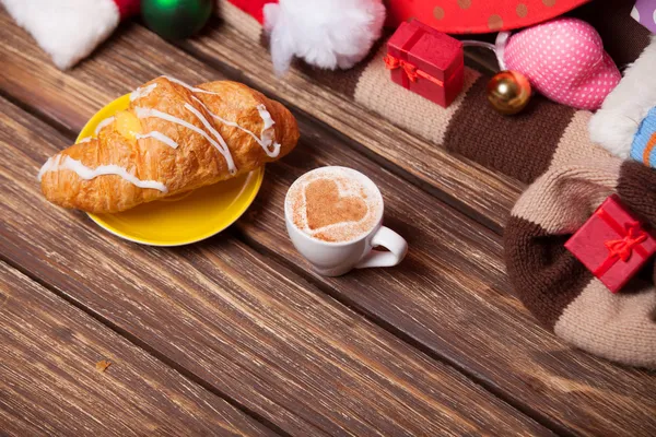 Чашка кофе и круассан на рождественском фоне . — стоковое фото