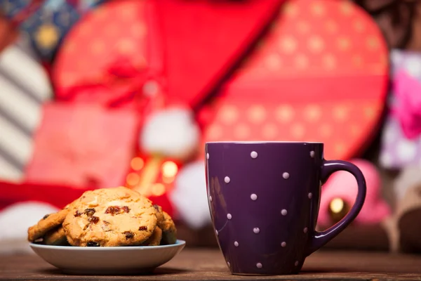 Plätzchen und Tasse Kaffee auf weihnachtlichem Hintergrund. — Stockfoto