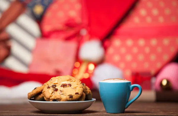 Plätzchen und Tasse Kaffee auf weihnachtlichem Hintergrund. — Stockfoto