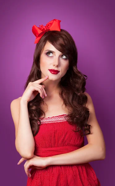 Surprised girl in red dress on violet background. — Stock Photo, Image