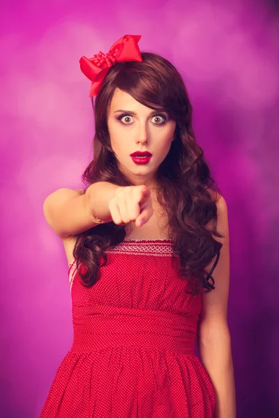 Surprised girl in red dress on violet background. — Stock Photo, Image