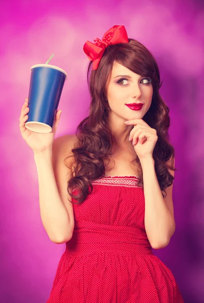 Brünettes Mädchen mit Flasche auf violettem Hintergrund. — Stockfoto