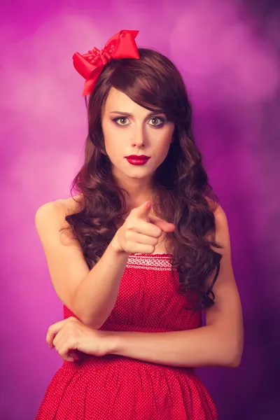 Surprised girl in red dress on violet background. — Stock Photo, Image