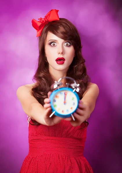 보라색 배경에 알람 시계와 놀된 여자. — 스톡 사진