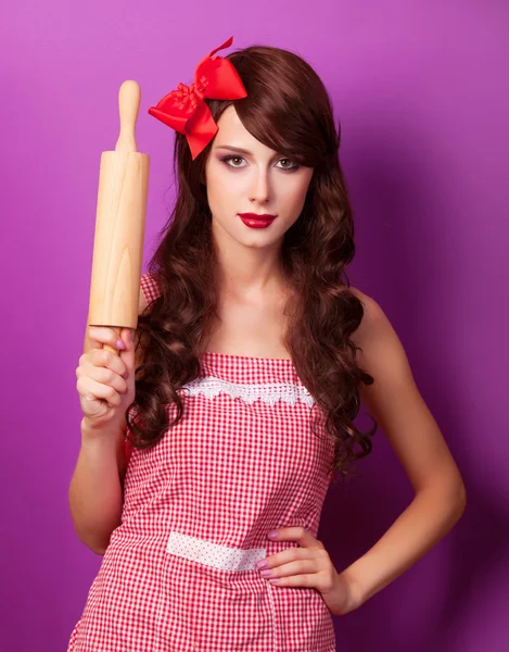 Belle femme au foyer brune avec rouleau à pâtisserie sur backgrou violet — Photo