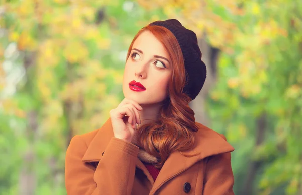 Redhead girl in autumn park — Stock Photo, Image