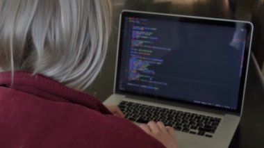 Ev ofisinde bilgisayarla çalışan kadın geliştirici.