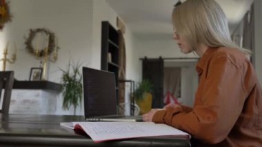 Ev ofisinde bilgisayarla çalışan kadın geliştirici.