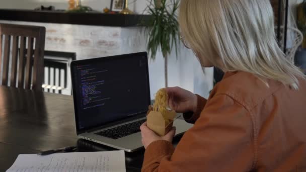 Χαμογελαστή Γυναίκα Προγραμματιστής Τρώει Ασιατικές Χυλοπίτες Στο Γραφείο — Αρχείο Βίντεο