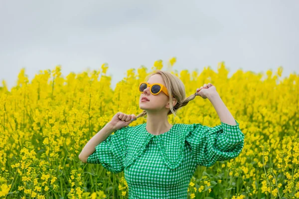 Mooie Blonde Gele Zonnebril Groene Jurk Geel Koolzaad Veld — Stockfoto