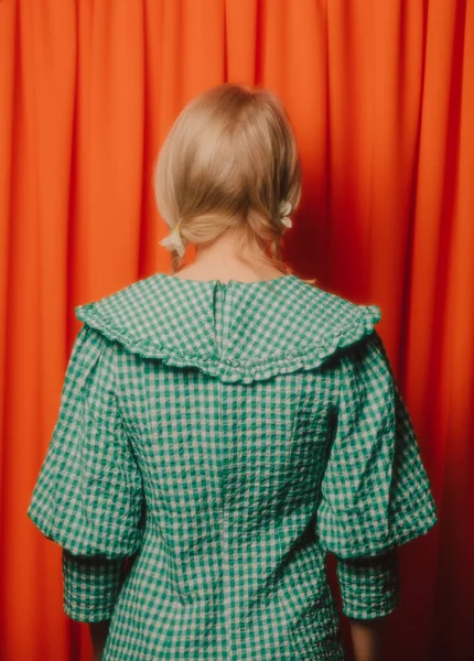 Κορίτσι Ένα Πράσινο Φόρεμα Κρύβει Κεφάλι Της Πορτοκαλί Κουρτίνες — Φωτογραφία Αρχείου
