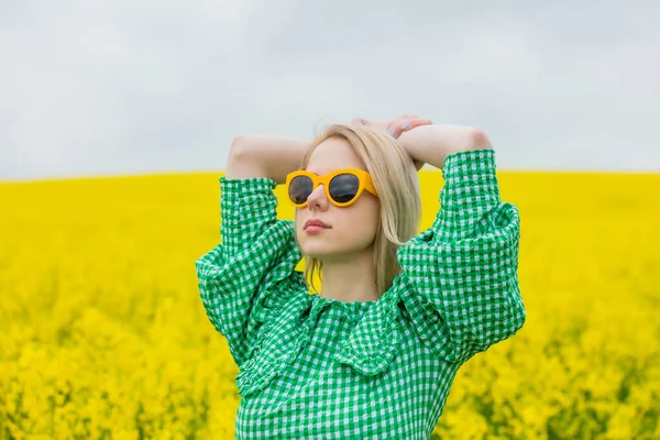 Mooie Blonde Gele Zonnebril Groene Jurk Geel Koolzaad Veld — Stockfoto