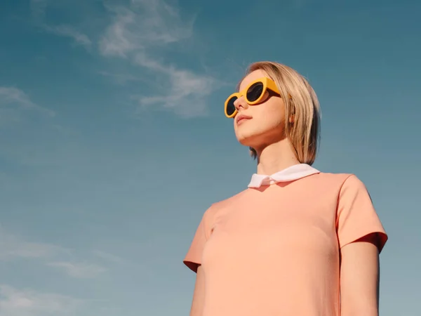 Stijl Vrouw Roze Jurk Met Gele Bril Blauwe Hemel Achtergrond — Stockfoto