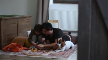 baba, oğul ve köpek evde oynuyorlar. 