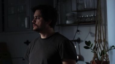 Ev çekimlerinde mutfakta duran düşünceli adam. 