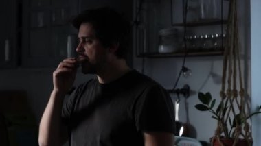 Adam mutfakta yemek yiyor.