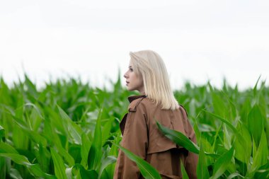 Yazın mısır tarlasında pelerinli sarışın kadın 
