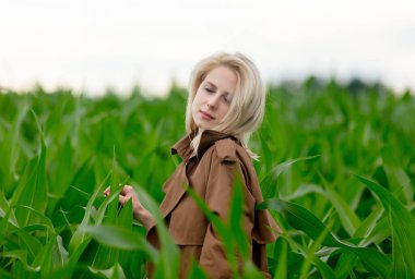 Yazın mısır tarlasında pelerinli sarışın kadın 