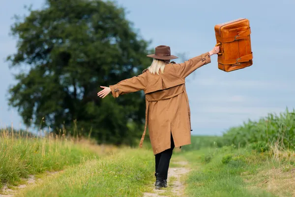 Blondine Vrouw Mantel Hoed Met Koffer Wandelen Het Platteland Weg — Stockfoto