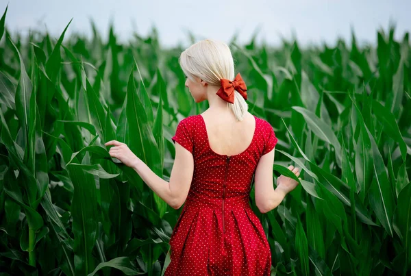 在玉米田里穿着漂亮红色衣服的金发女士 — 图库照片